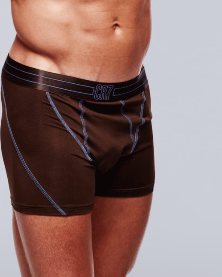Brown boxer briefs with blue contrast stitching and a CR7 waistband worn against a light studio background