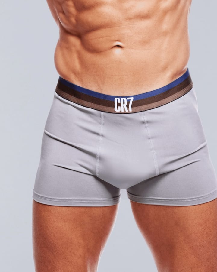 Hellgraue Boxershorts mit braun-blauem CR7-Bund am Körper vor hellem Studiohintergrund